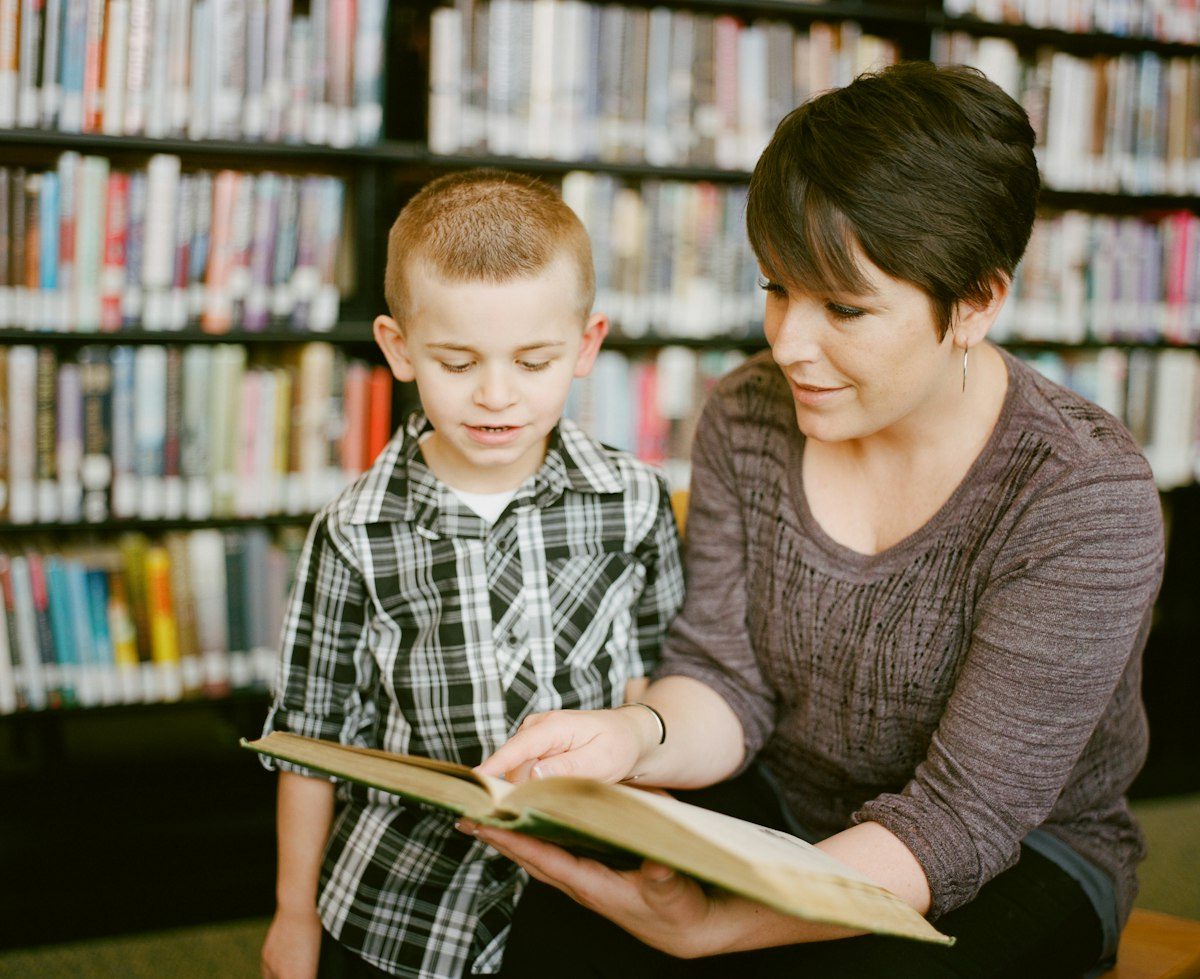 A tutor reading one on one with a young student