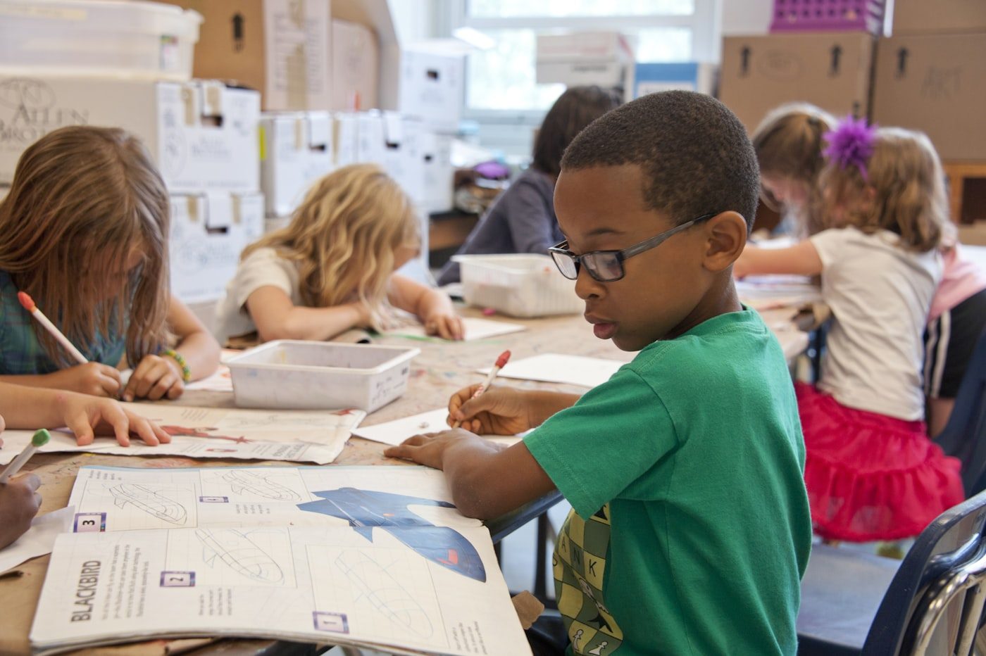 A young student working through a writing exercise